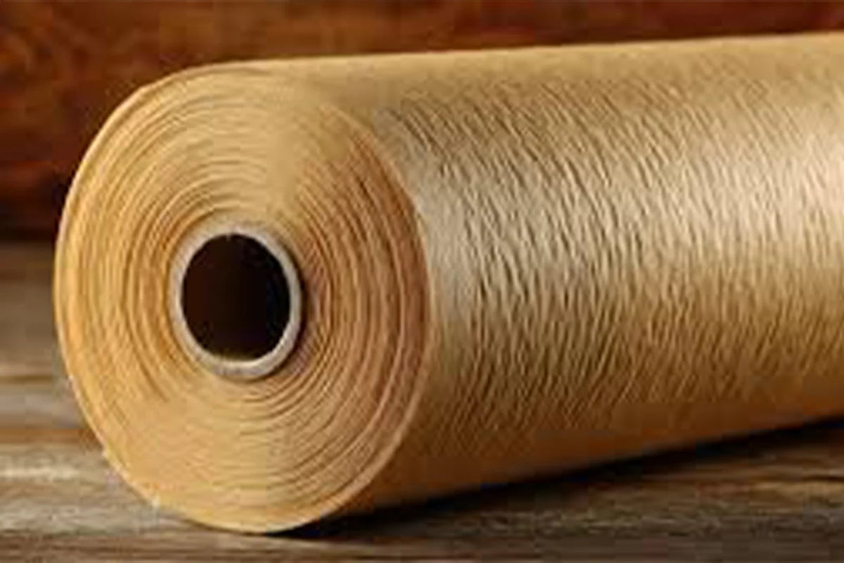A close-up of a large roll of tan or light brown material,